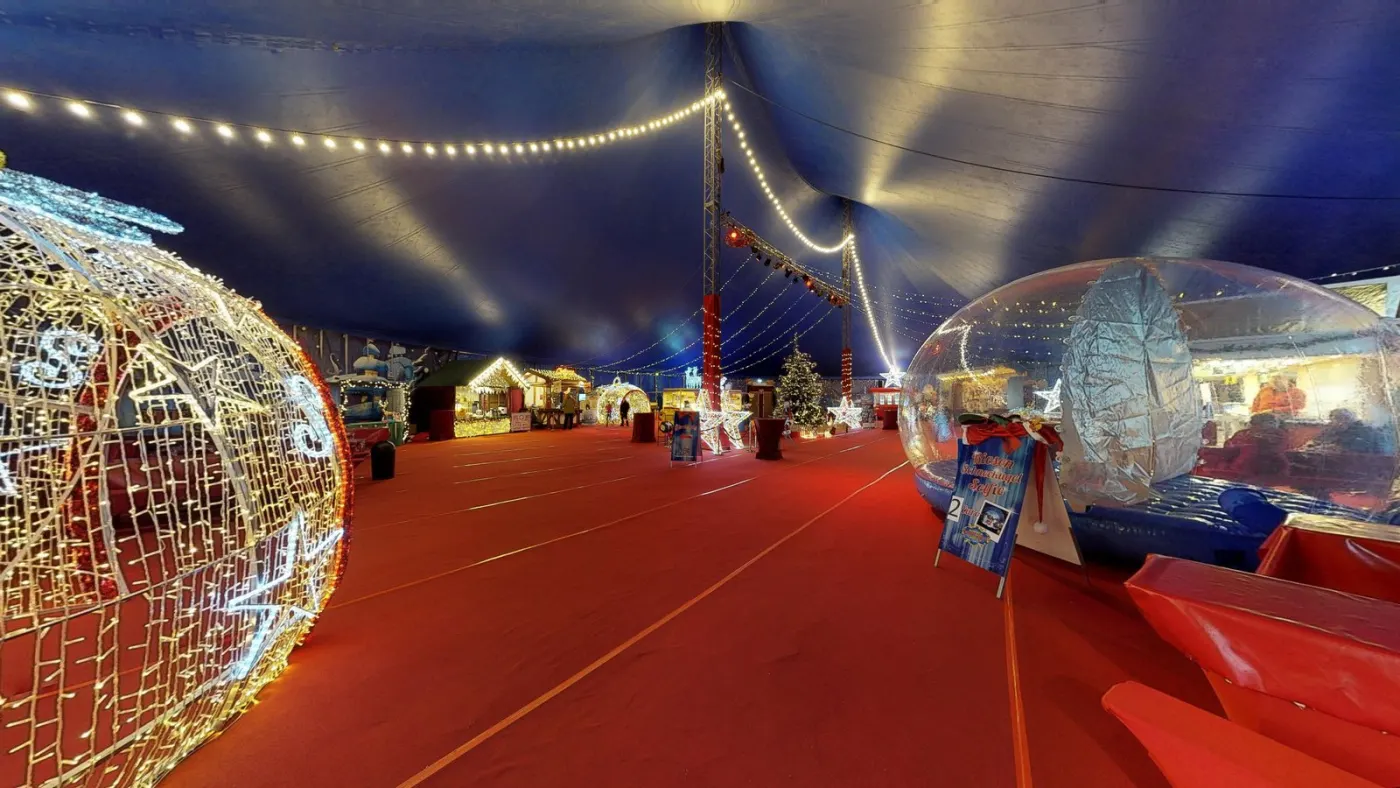 Blick in die beleuchtete Zeltstadt des Bonner Weihnachtscircus mit Lichterketten und Weihnachtsschmuck